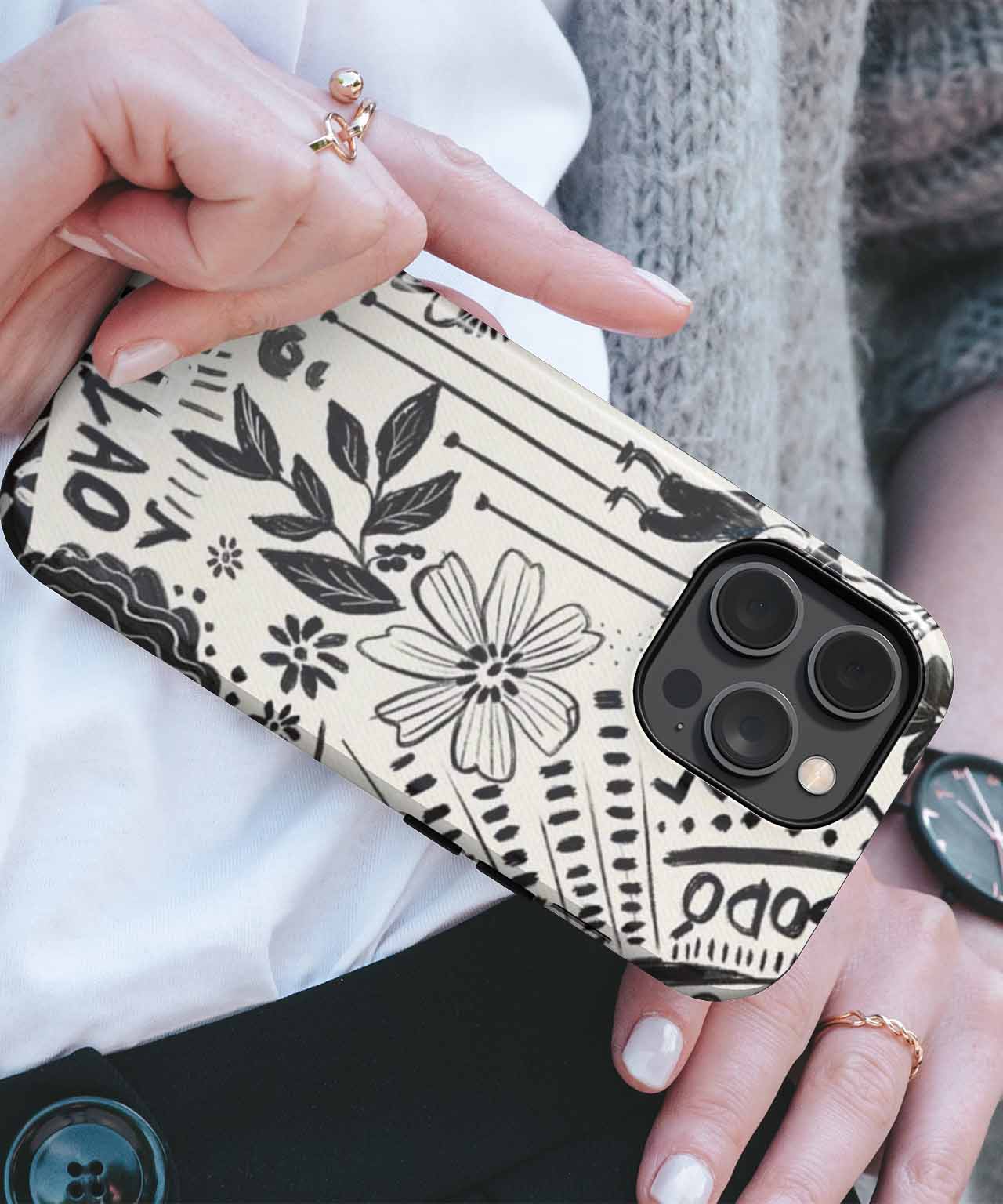 Black and white floral patterned protective phone case on iPhone with triple camera lenses. - Cazify Canada