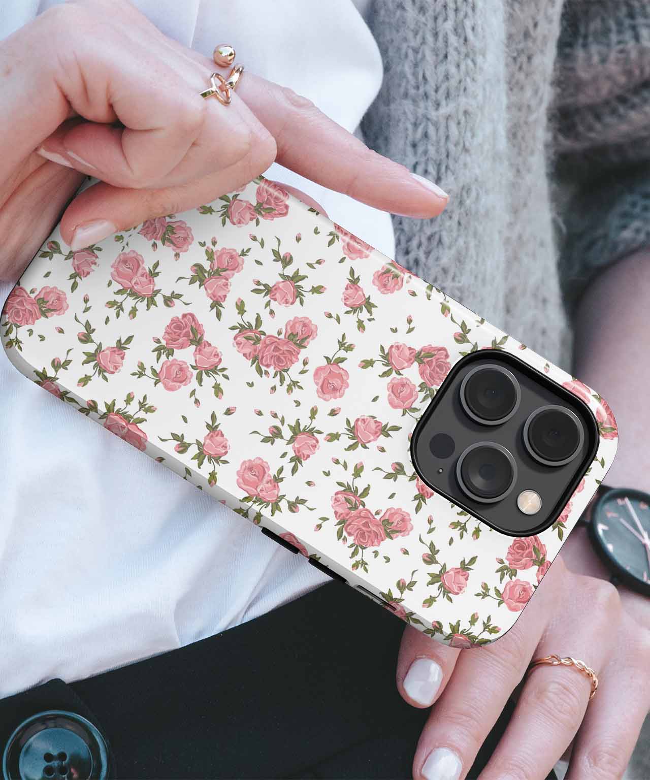 Floral pattern phone case with pink roses and green leaves on a cream background, fitted on a black iPhone with triple. - Cazify Canada