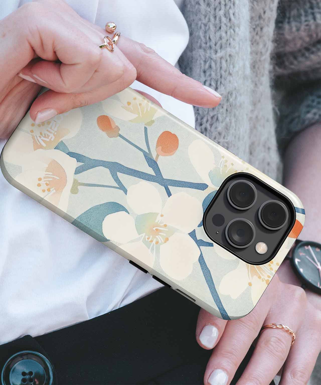 Floral print iPhone case with beige background and green and orange design on a Pro model phone. - Cazify Canada