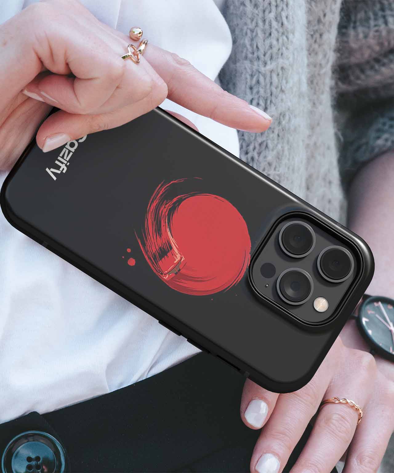Black iPhone case with a red circular brushstroke design and triple camera cutout. - Cazify Canada