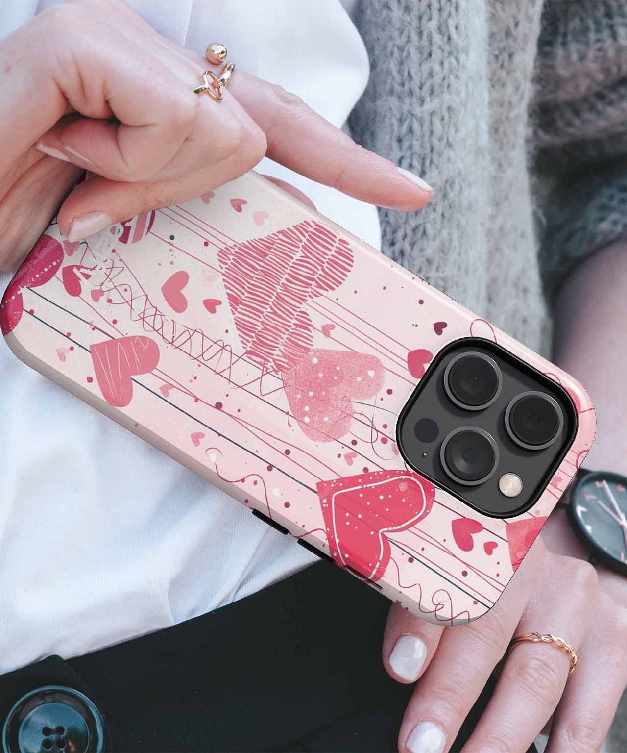 Pink iPhone case with red hearts and intricate line patterns on black camera cutout phone. - Cazify Canada