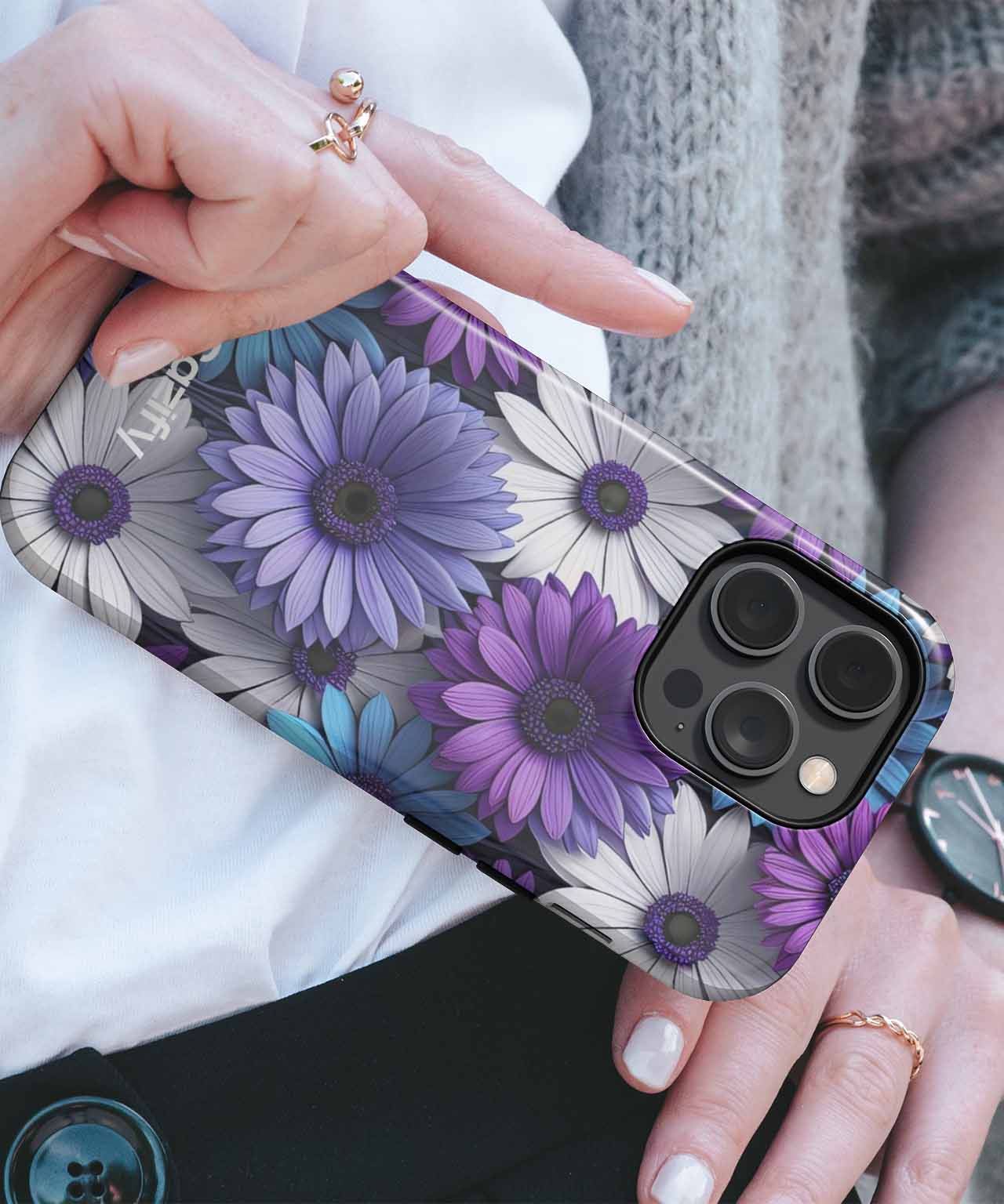 Purple and white floral patterned iPhone case on a dark phone with triple camera lenses. - Cazify Canada