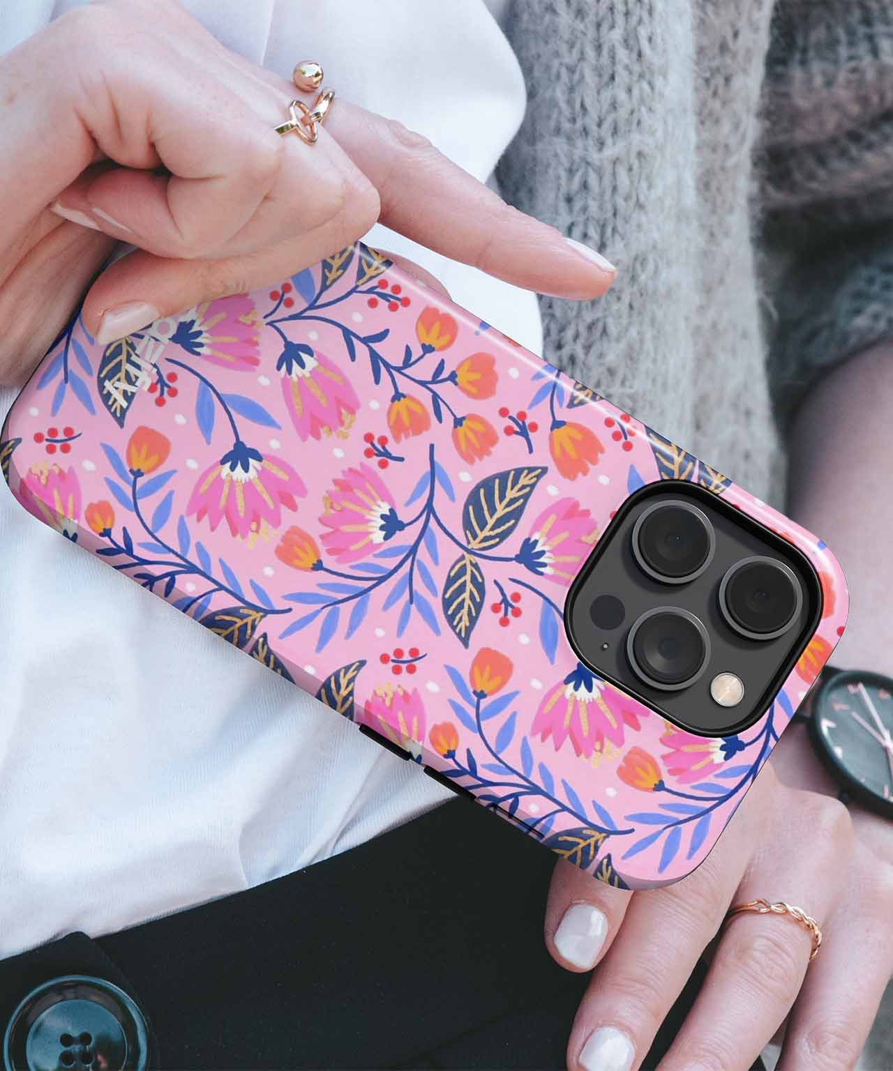 Pink floral pattern phone case with blue, orange, and green accents on a black iPhone camera module. - Cazify Canada