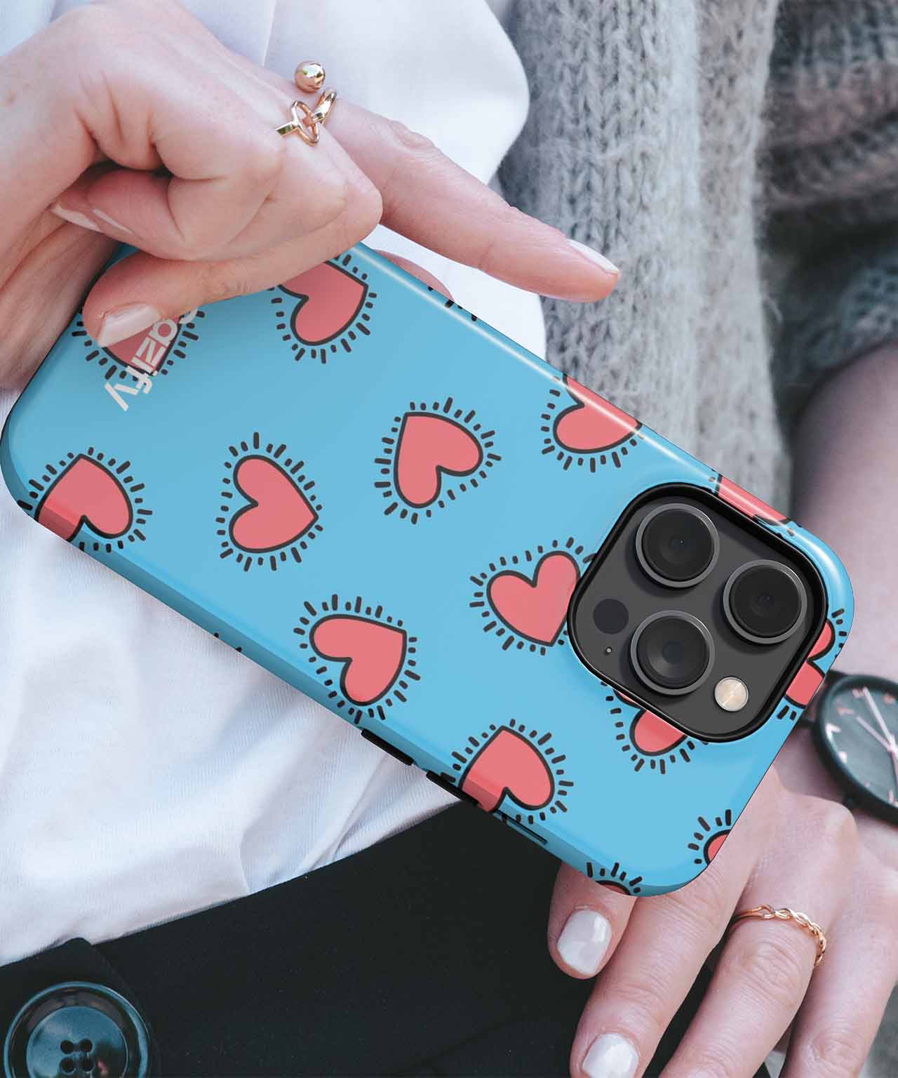 Blue phone case with pink heart and black line pattern on a smartphone with triple camera lenses. - Cazify Canada