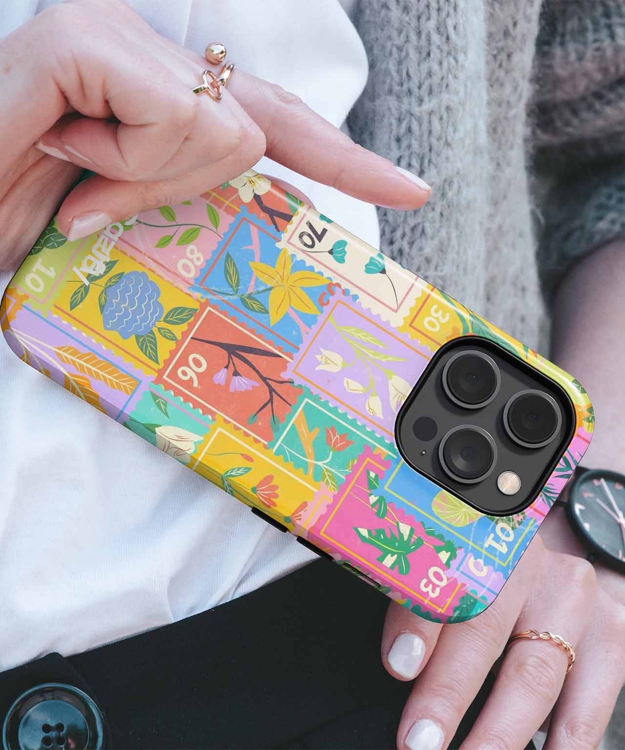 Colorful patchwork-style iPhone case with various floral and abstract designs on a black phone. - Cazify Canada