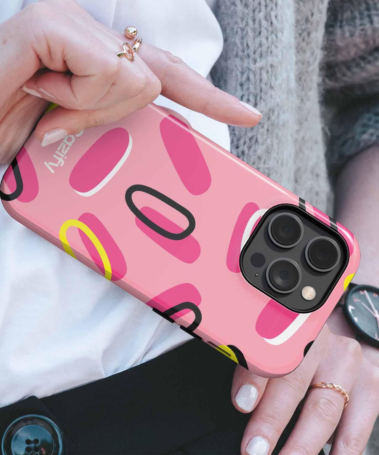 Pink phone case with abstract oval patterns in black, yellow, and darker pink on an iPhone. - Cazify Canada