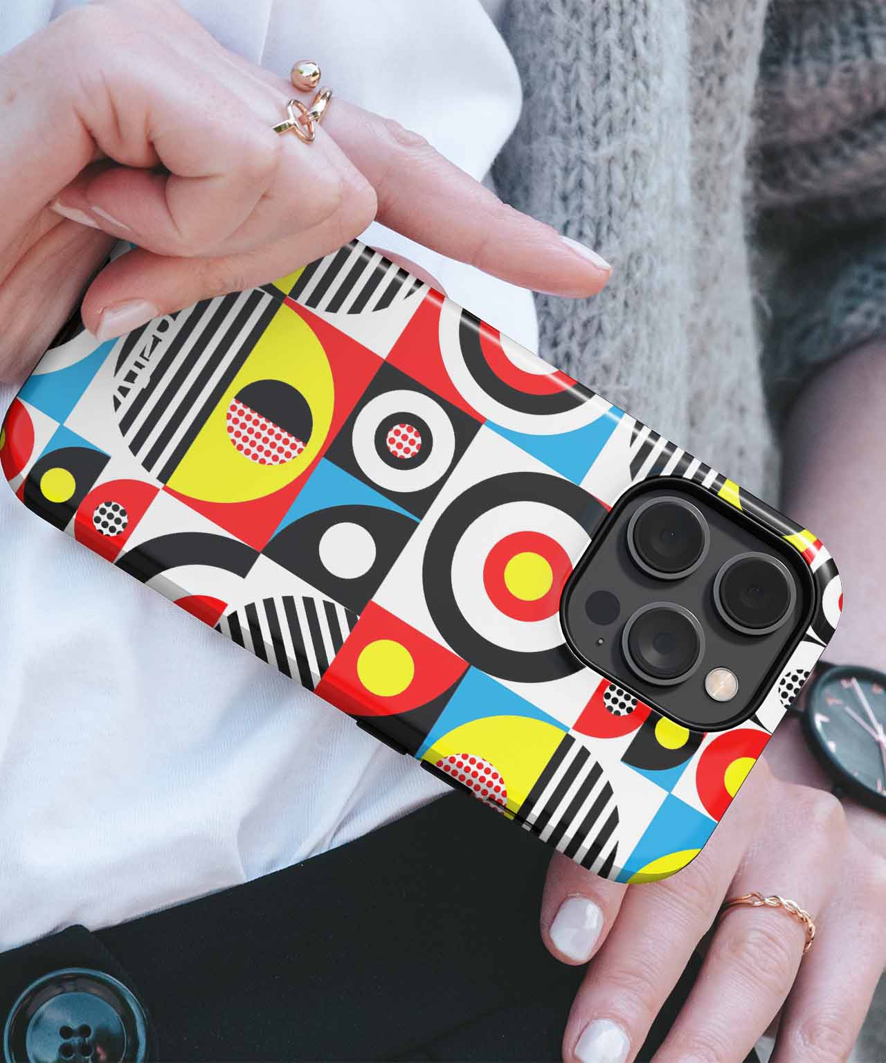 Colorful geometric pattern phone case with bold circles, stripes, and abstract shapes on black iPhone. - Cazify Canada