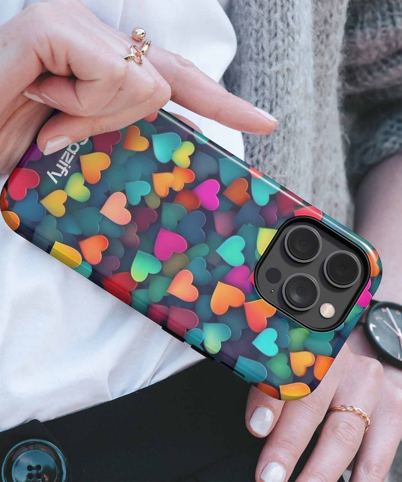 IPhone with colorful heart pattern protective case and black camera lenses visible. - Cazify Canada