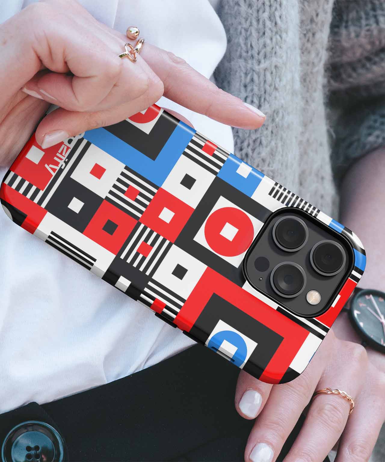 Phone case with red, blue, black, and white geometric abstract pattern on an iPhone with triple camera lenses. - Cazify Canada