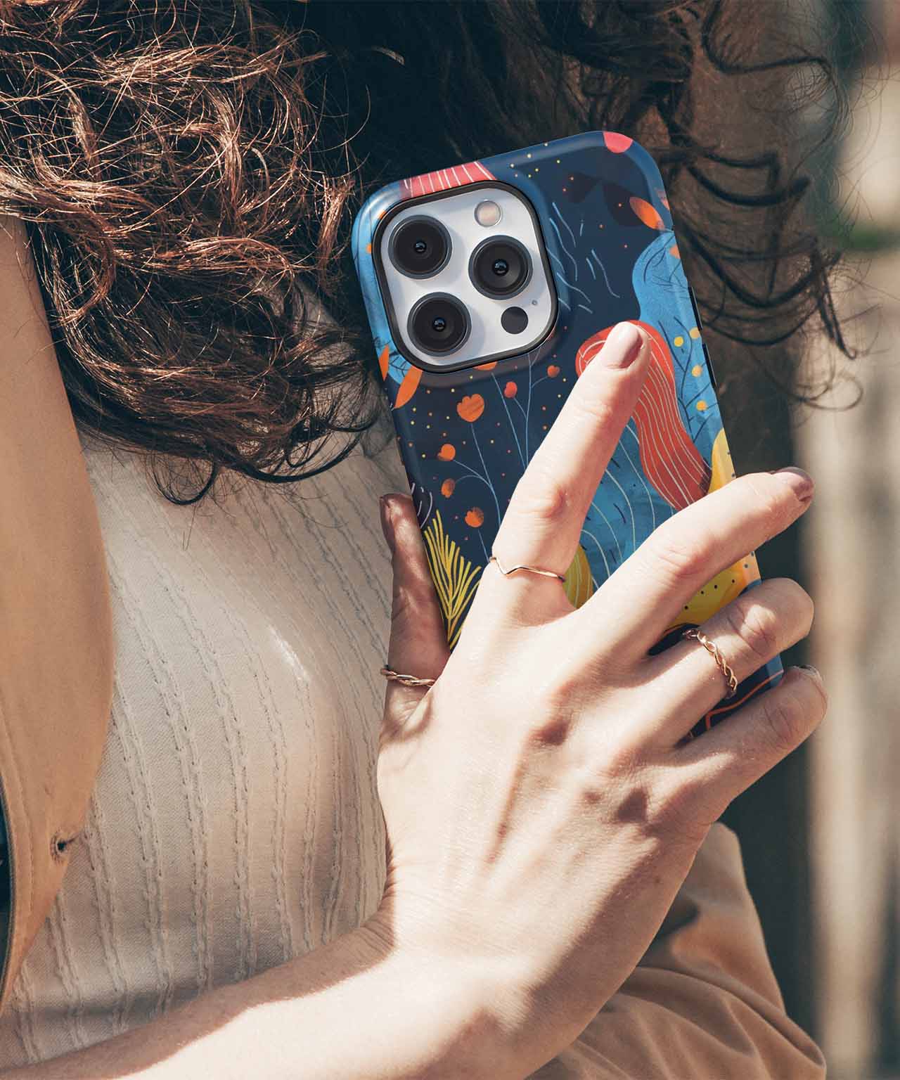 Blue phone case with colorful abstract shapes on iPhone with triple camera lenses. - Cazify Canada