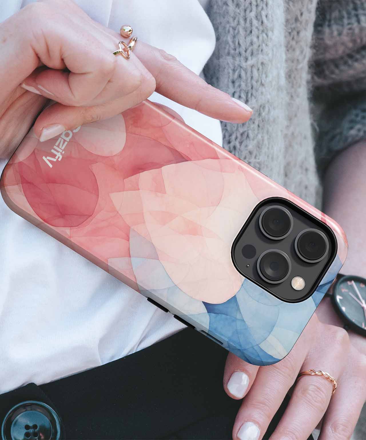 Glossy phone case with abstract overlapping pink, peach, and blue shapes on iPhone with triple camera lenses. - Cazify Canada