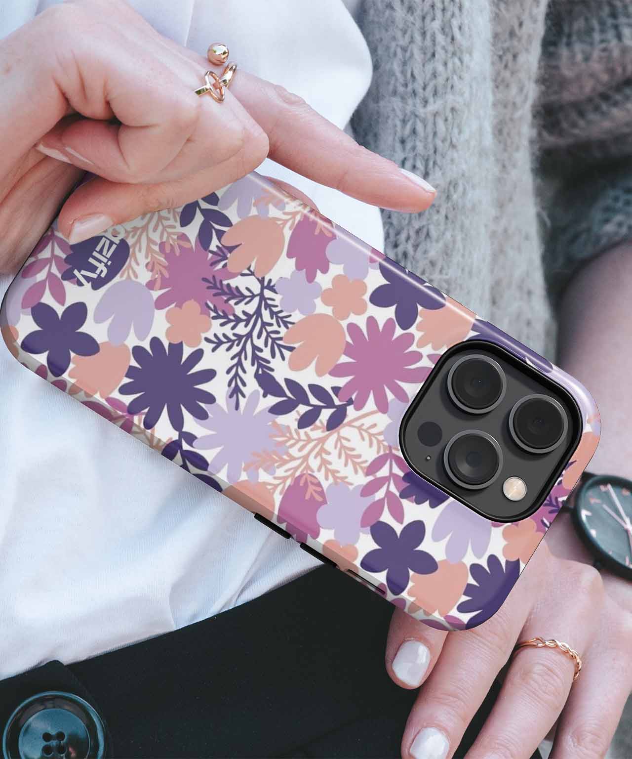 Purple and pink floral patterned iPhone case with gold accents on hand. - Cazify Canada