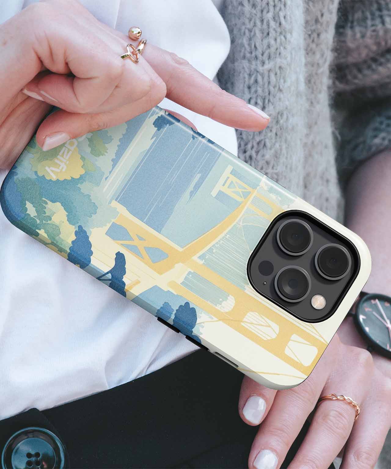 Cazify Canada - IPhone with case featuring yellow bridge and blue sky design, slim profile.