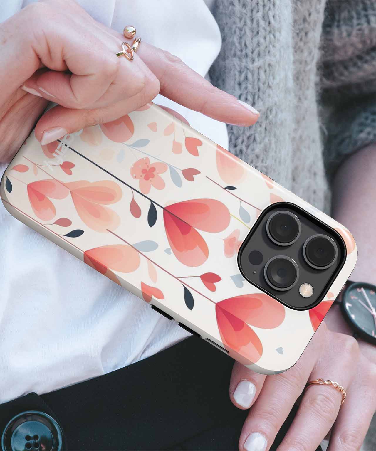 IPhone with beige case featuring red and pink heart and flower pattern. - Cazify Canada