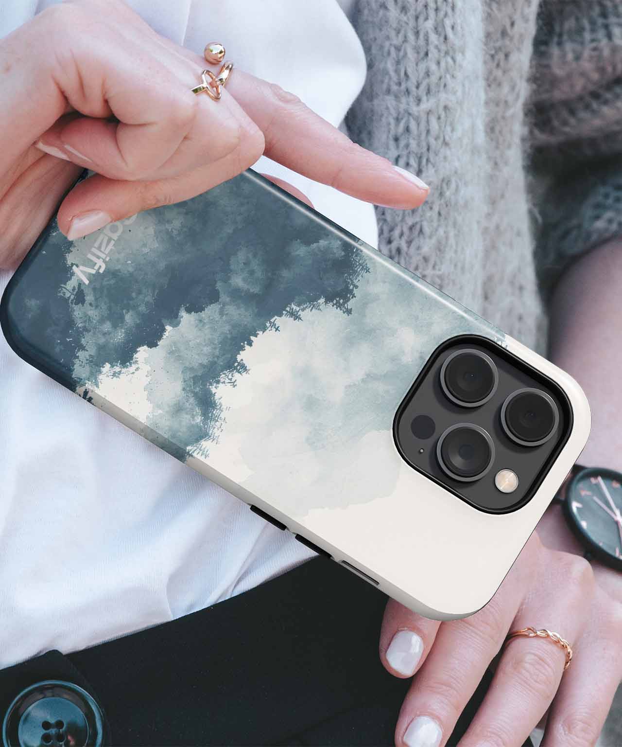Cazify Canada - Smartphone with a cloudy sky design case and triple camera lenses held in hand.