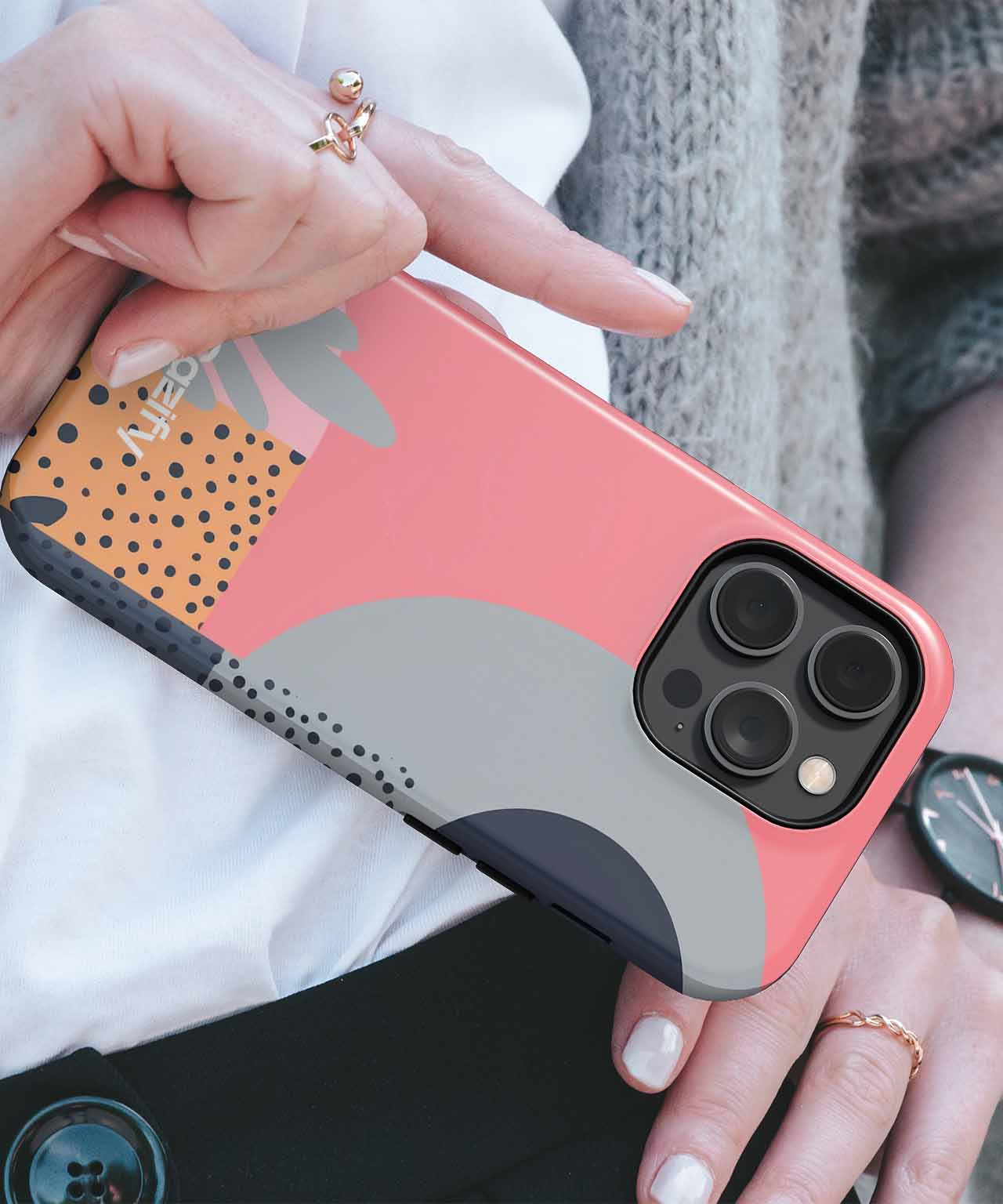 Coral phone case with black, gray, and beige abstract shapes and dots on an iPhone. - Cazify Canada