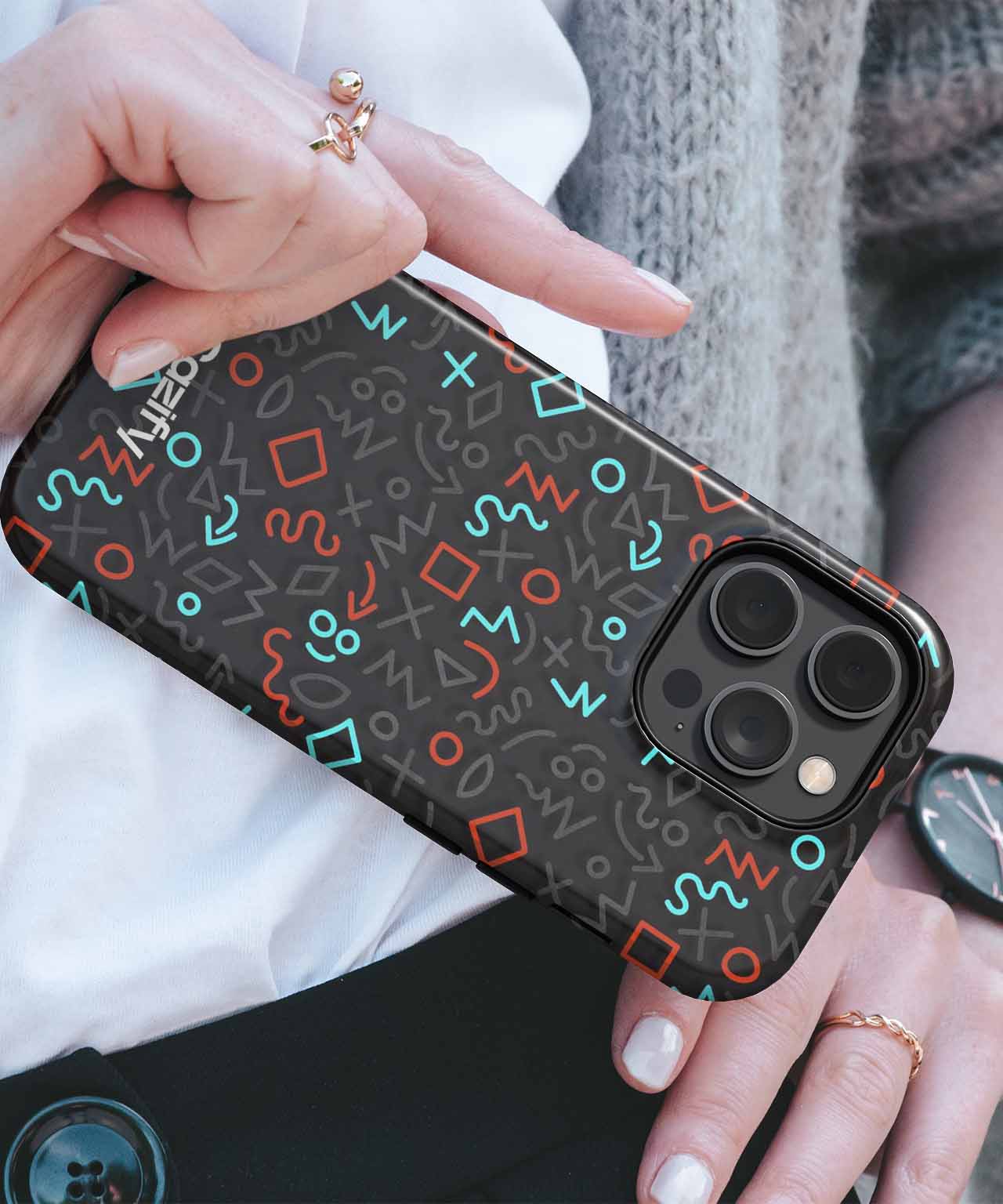 Black phone case with colorful abstract shapes and symbols on an iPhone with triple camera lenses. - Cazify Canada