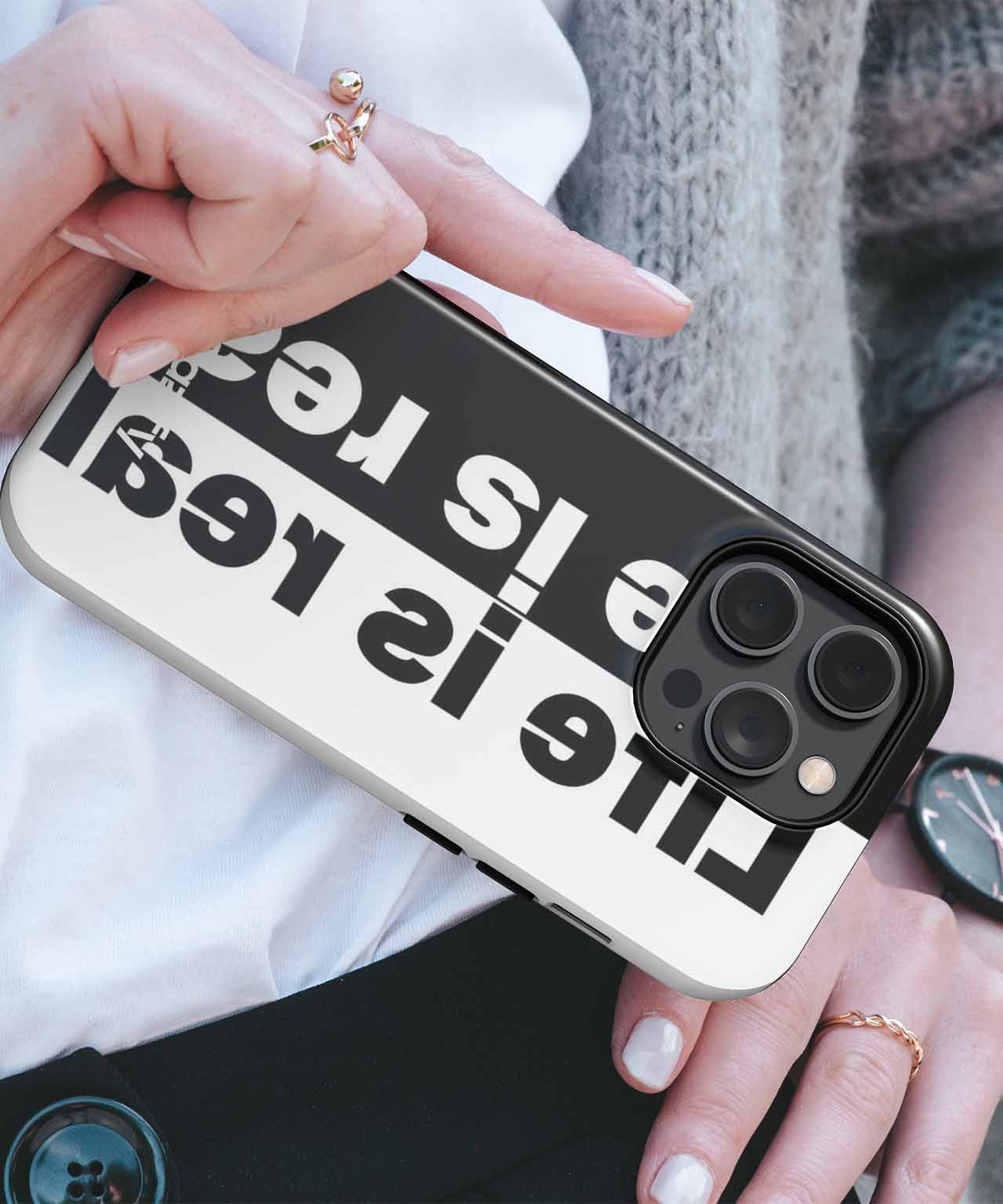 Black iPhone case with large white text "Life is real" in bold letters. - Cazify Canada