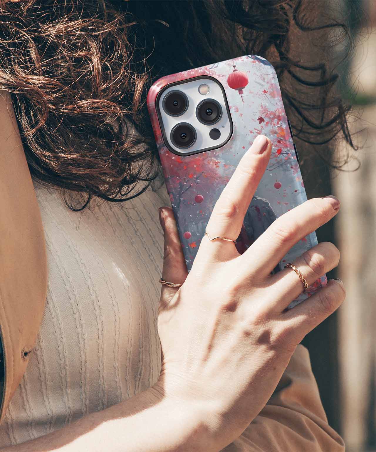 Clear phone case with pink and red paint splatter design on silver iPhone with triple rear cameras. - Cazify Canada