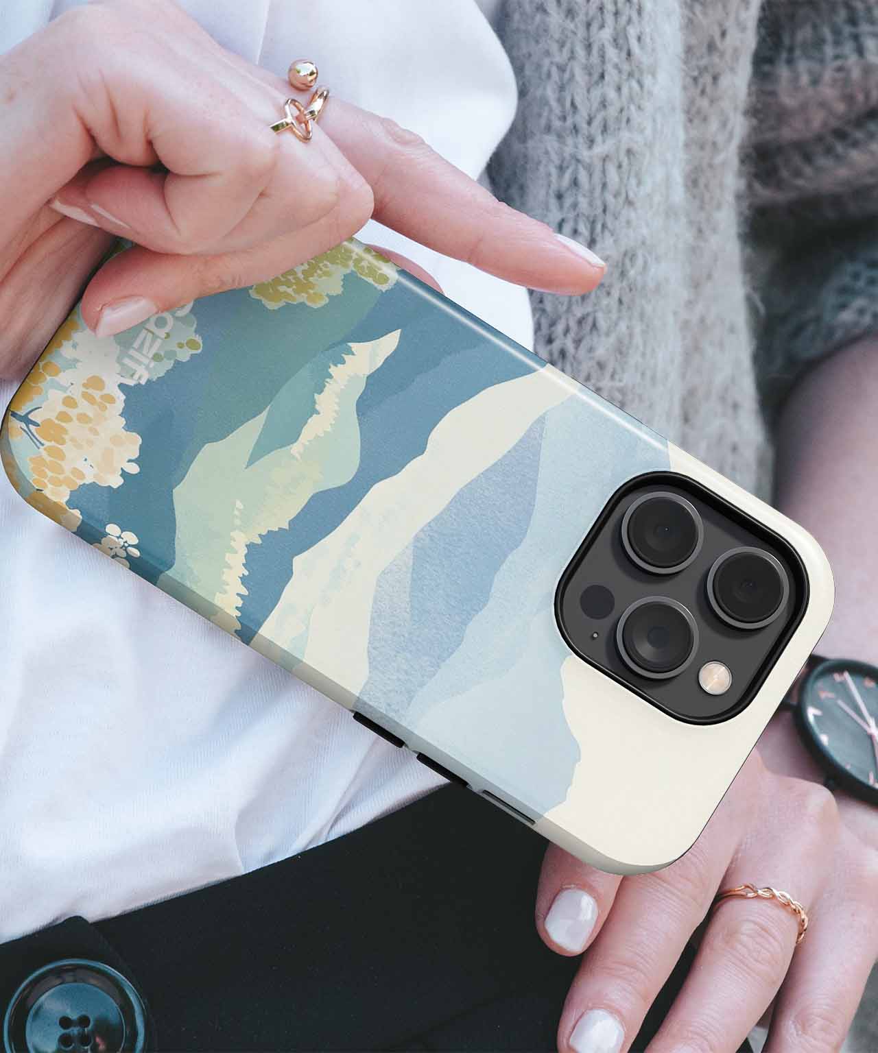 Cazify Canada - Protective phone case with abstract green, blue, and yellow mountain design on a smartphone with triple-camera module.