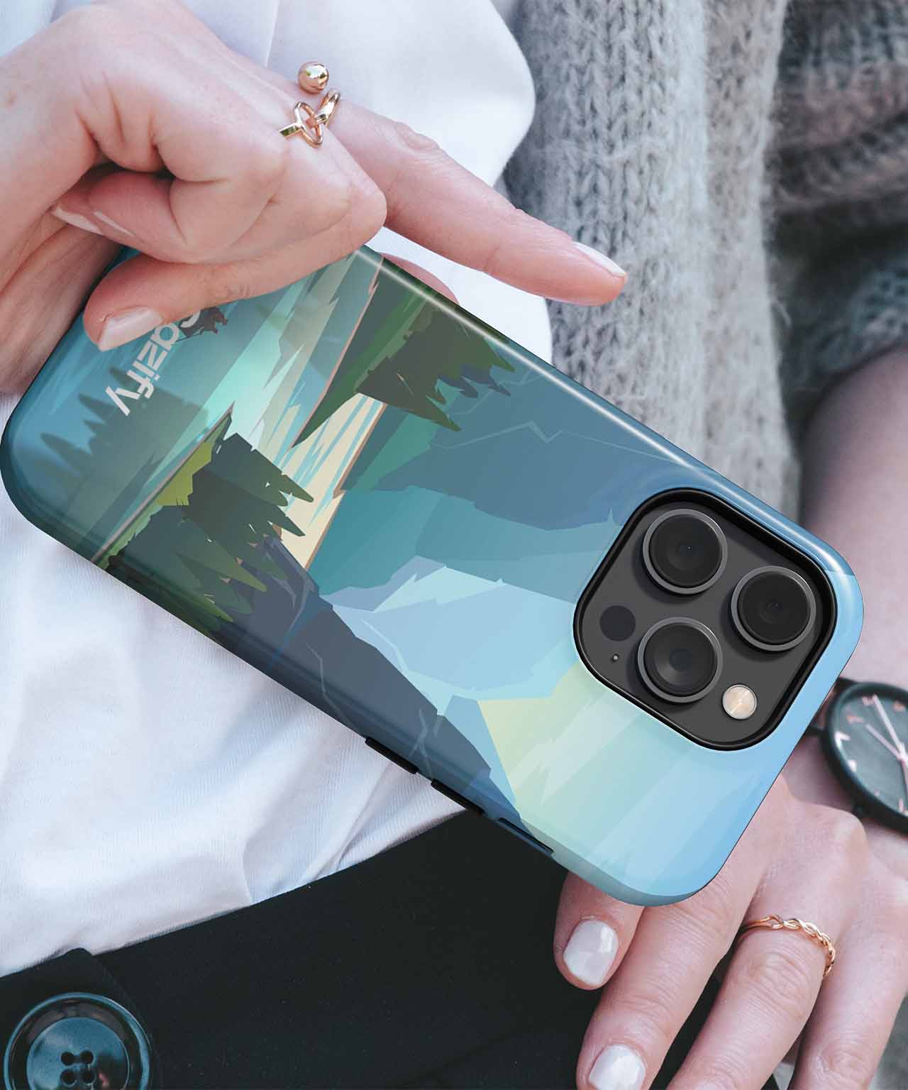 Cazify Canada - Blue iPhone with abstract mountain landscape case, held in hand with gold rings.