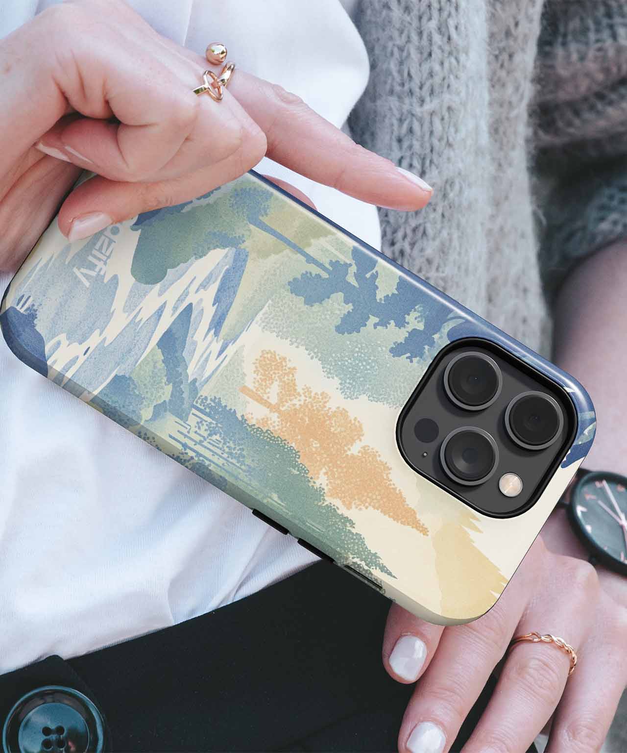 Cazify Canada - IPhone with abstract green, beige, and blue artistic case and triple camera lenses.