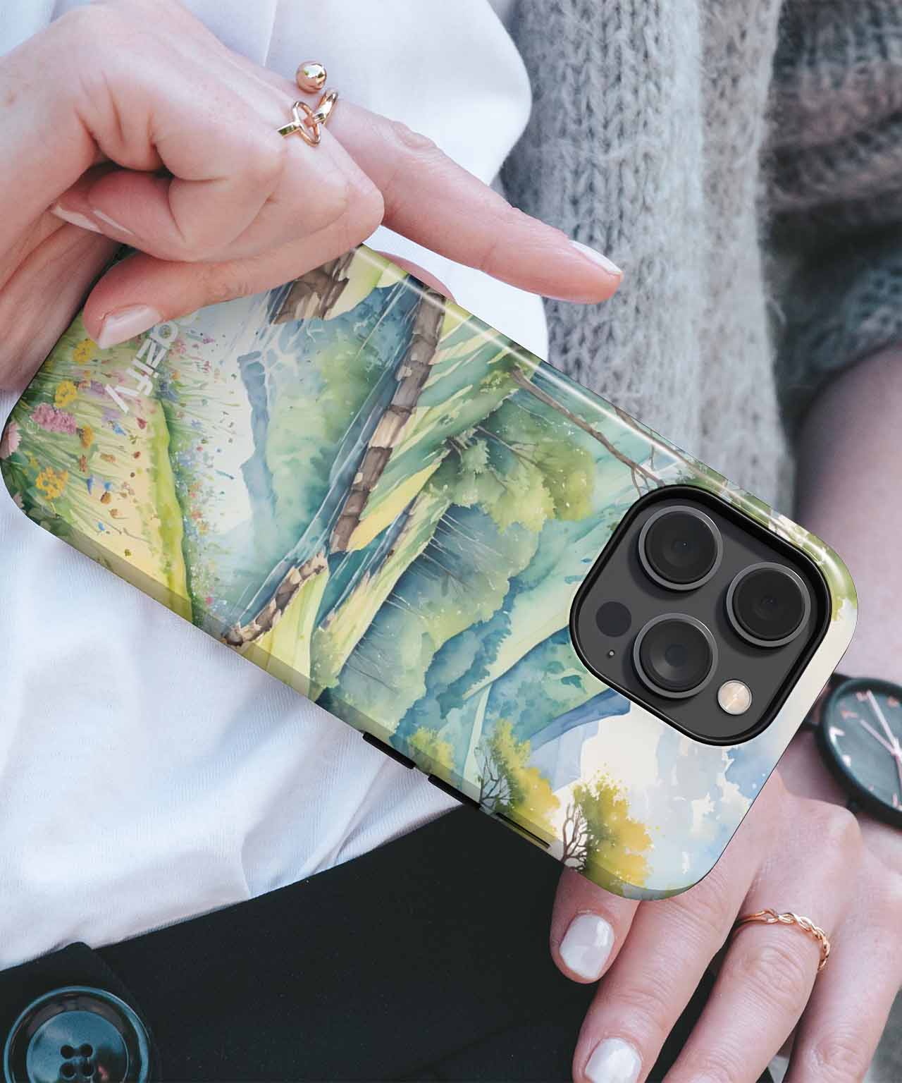 Cazify Canada - Watercolor mountain landscape iPhone case with green and blue tones on a black camera lens phone variant.