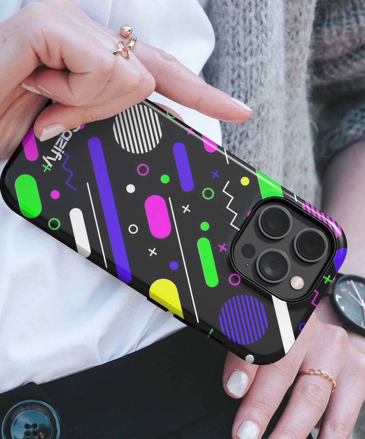 Black phone case with colorful geometric shapes and patterns, fitted on an iPhone with triple camera lenses. - Cazify Canada