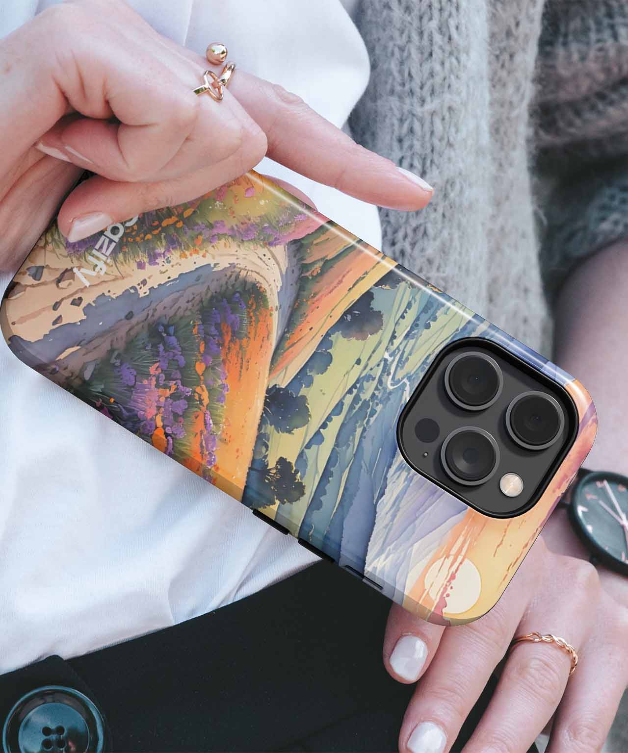 Cazify Canada - IPhone with artistic sunset landscape case featuring a large tree and mountains in warm tones.