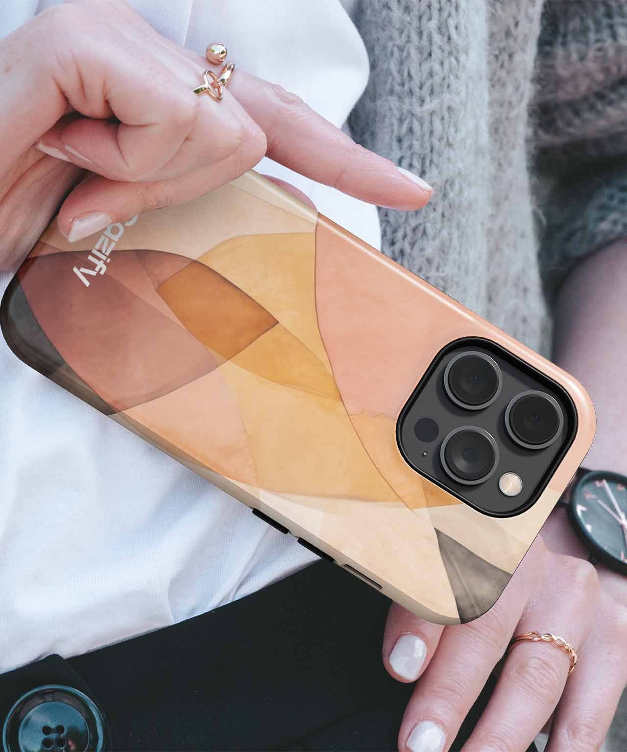 Phone case with abstract geometric pattern in warm tan, brown, and beige tones on an iPhone with triple cameras. - Cazify Canada