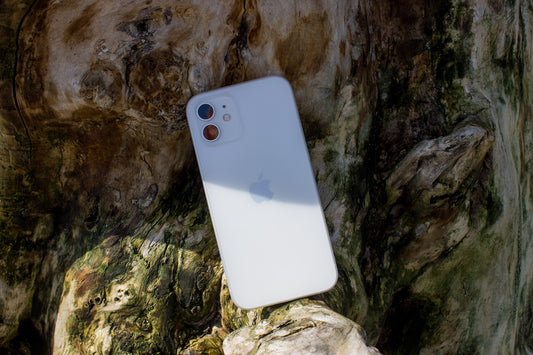 a white iphone sitting on top of a rock
