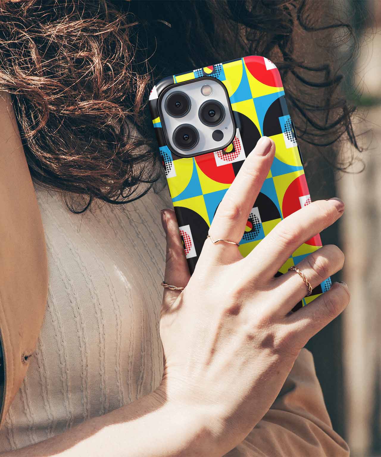 Colorful geometric pattern phone case on silver iPhone with triple camera lenses. - Cazify Canada