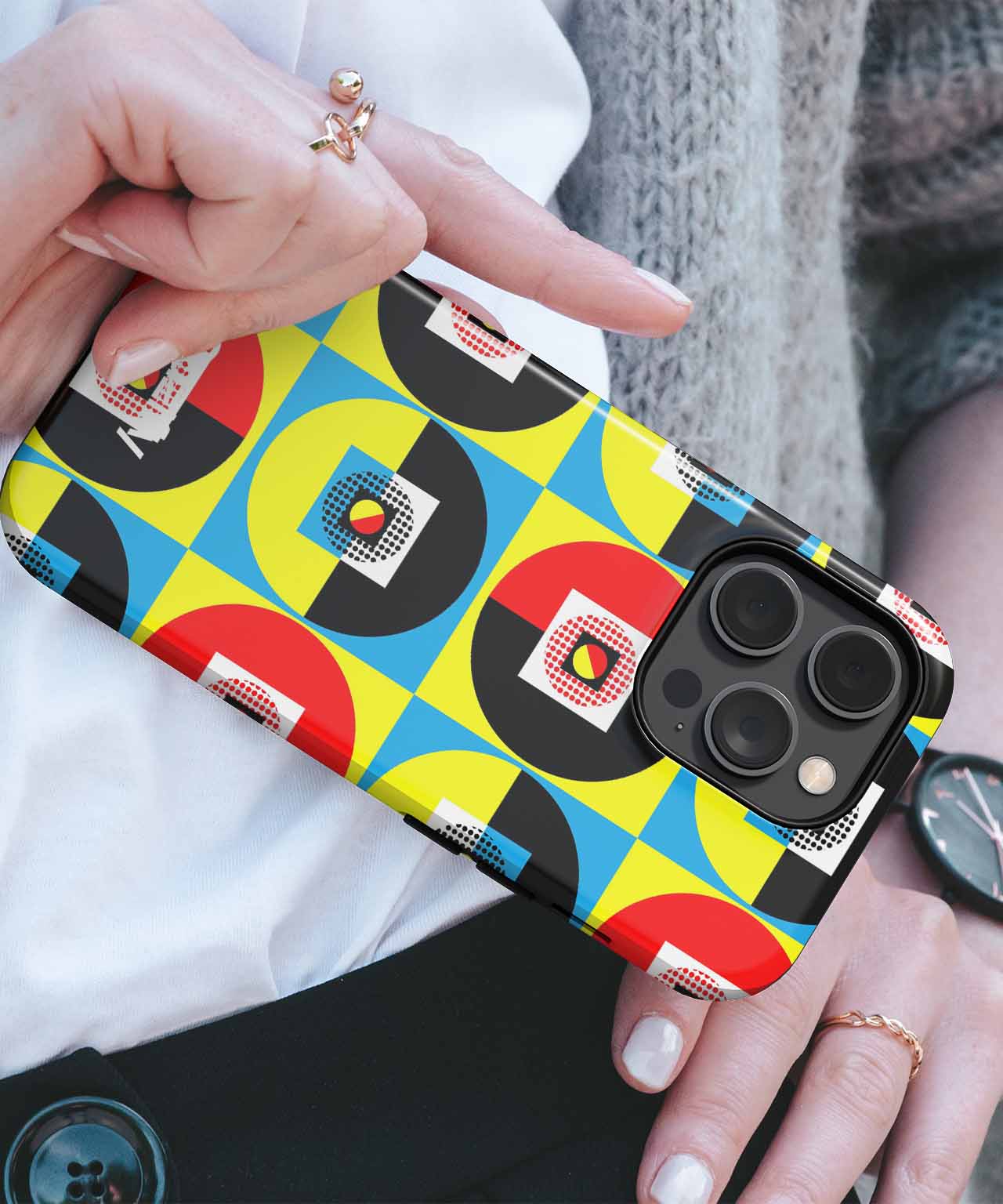 Colorful geometric patterned phone case on black iPhone with triple camera lenses. - Cazify Canada