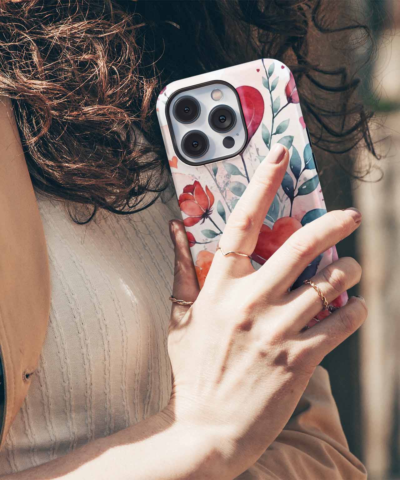 Cazify Canada - Floral patterned phone case featuring pink and red flowers on a white background, fitted on a silver iPhone with triple.