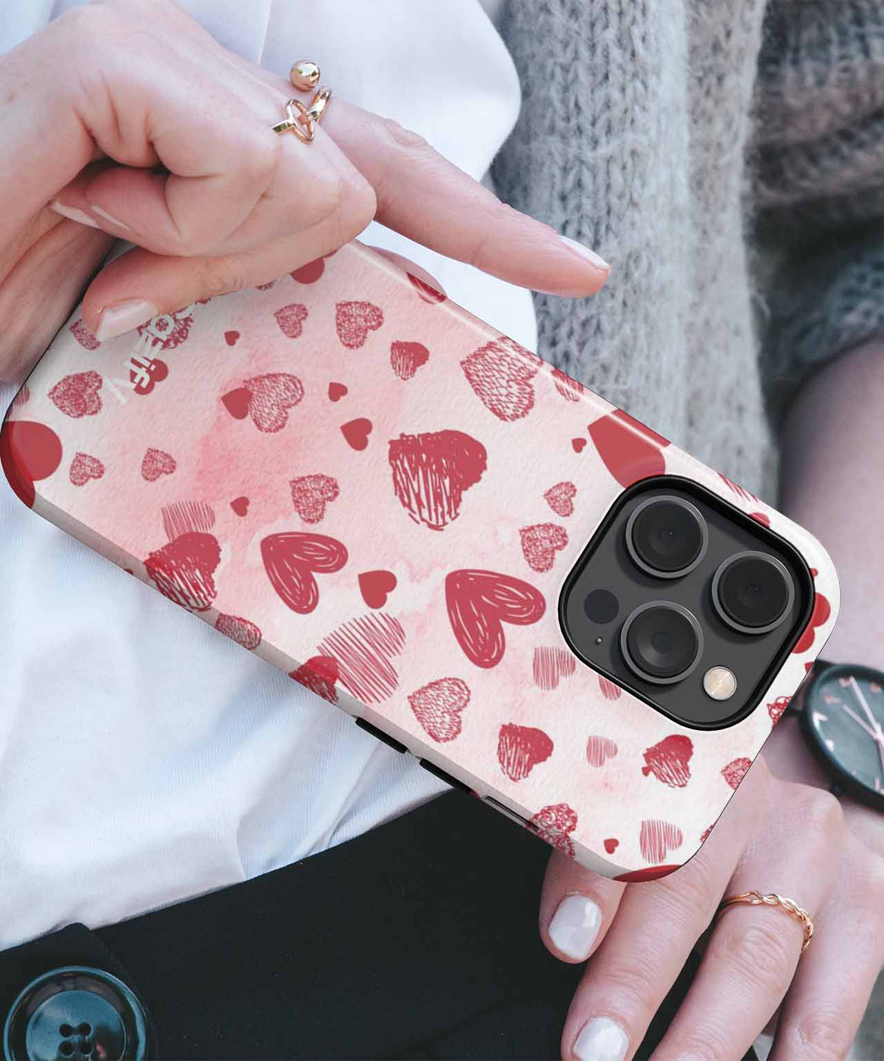 Pink iPhone case with various red heart patterns on a white background. - Cazify Canada