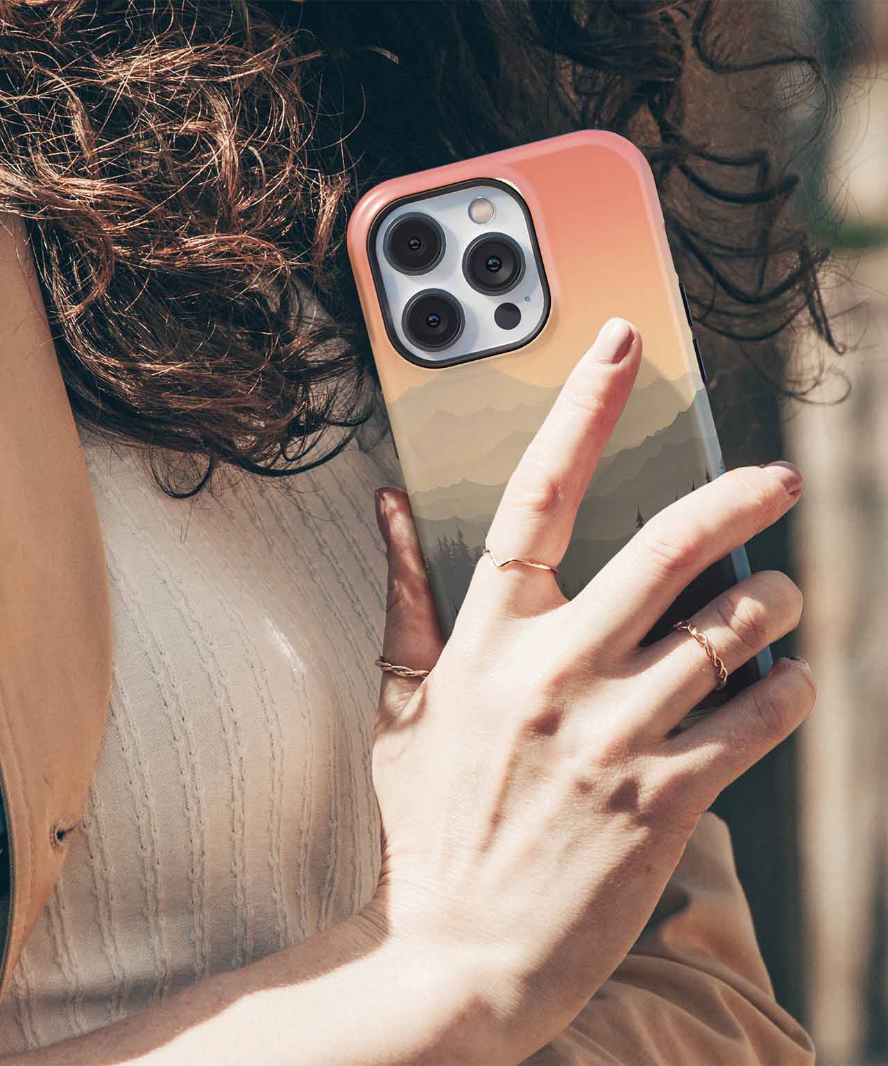 Cazify Canada - Clear protective phone case with reinforced edges on an iPhone with triple camera lenses and gradient sunset background.